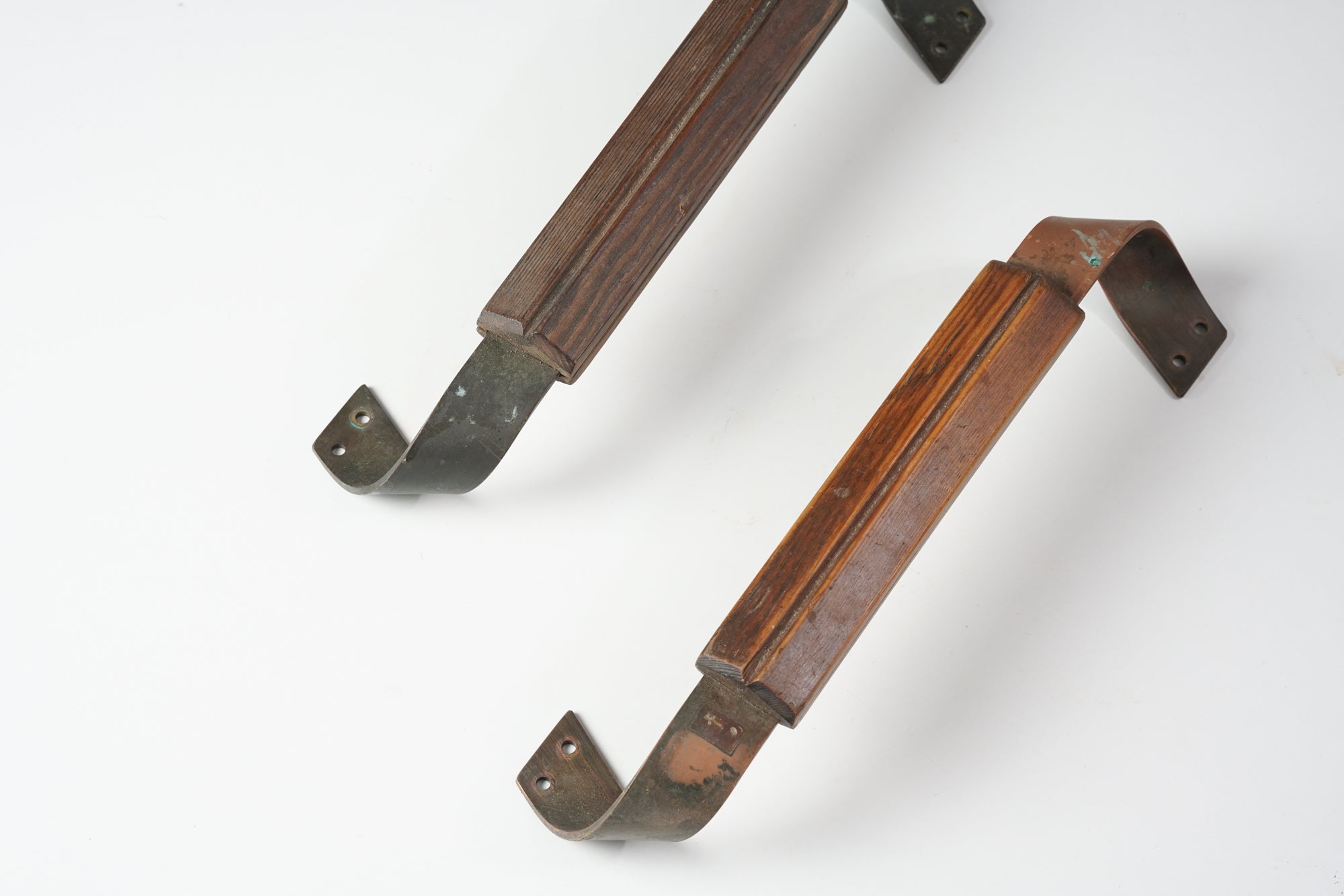 Two door handles made of pine and copper. The pine has a slight shade difference.